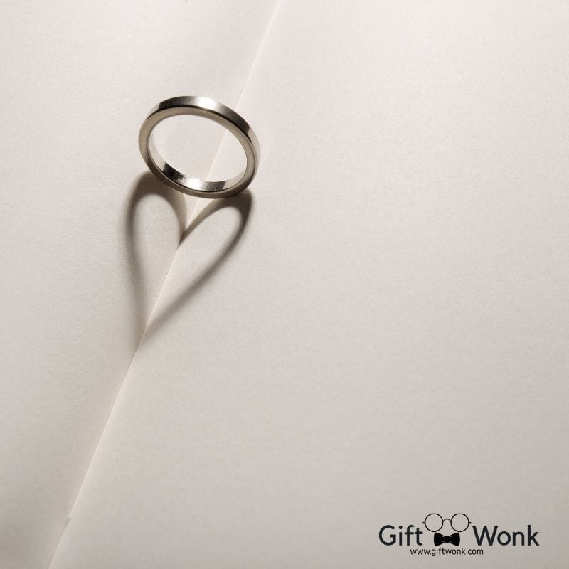A picture of a ring on a book with a shadow forming a heart